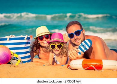 Happy family playing at the beach. Summer vacation concept