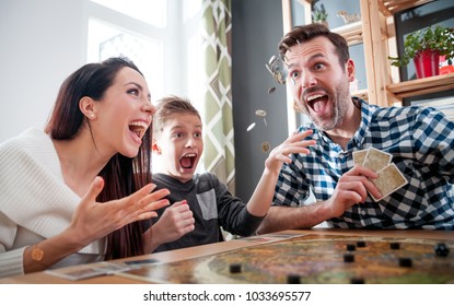 Happy Family Playing Board Game At Home, Boy Throwing Elements After Winning