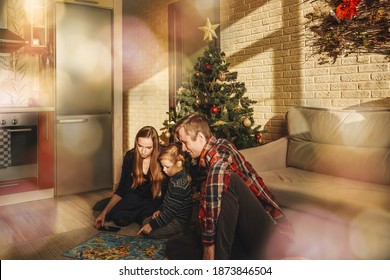 Happy Family Playing Board Game Walker At Home, Christmas Tree On Background. Holidays Home. Bokeh Around.