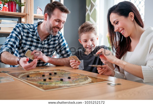 Happy family playing board game at home,\
happiness concept