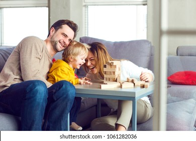 Happy Family Playing Board Games On The Table.