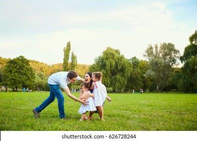 Happy Family Playing With Children In The Park. 