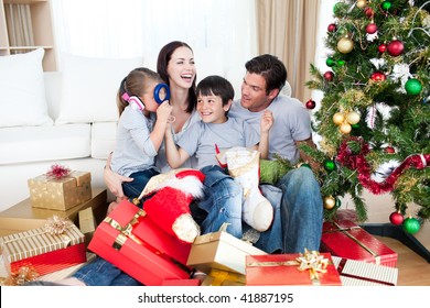 Happy Family Playing With Christmas Gifts At Home