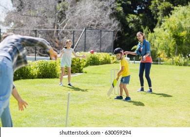 Happy family playing cricket together in backyard - Powered by Shutterstock