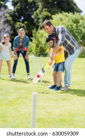 Happy Family Playing Cricket Together In Backyard