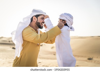 Happy family playing in the desert of Dubai -  Playful father and his son having fun outdoors - Powered by Shutterstock