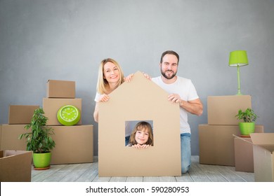 Happy family playing into new home. Father, mother and child having fun together. Moving house day and real estate concept