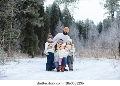 Happy Family Playing And Laughing In Winter Outdoors In Snow. City Park Winter Day.
