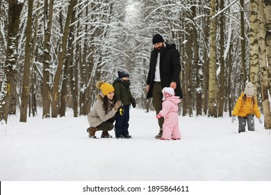 Happy Family Playing And Laughing In Winter Outdoors In Snow. City Park Winter Day.