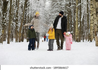 Happy Family Playing And Laughing In Winter Outdoors In Snow. City Park Winter Day.