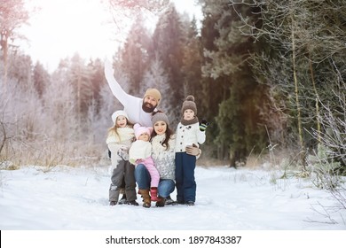 Happy Family Playing And Laughing In Winter Outdoors In Snow. City Park Winter Day.
