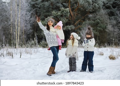 Happy Family Playing And Laughing In Winter Outdoors In Snow. City Park Winter Day.
