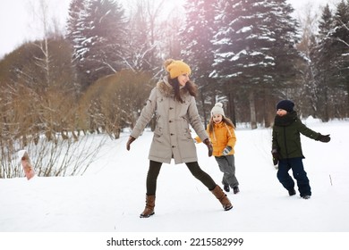 Happy Family Playing And Laughing In Winter Outdoors In Snow. City Park Winter Day.