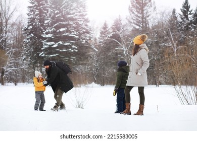 Happy Family Playing And Laughing In Winter Outdoors In Snow. City Park Winter Day.