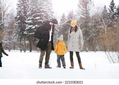 Happy Family Playing And Laughing In Winter Outdoors In Snow. City Park Winter Day.