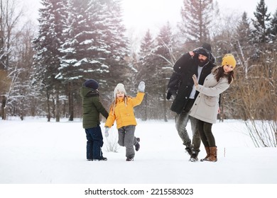 Happy Family Playing And Laughing In Winter Outdoors In Snow. City Park Winter Day.