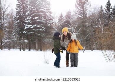 Happy Family Playing And Laughing In Winter Outdoors In Snow. City Park Winter Day.