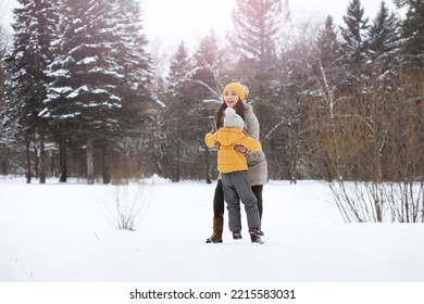 Happy Family Playing And Laughing In Winter Outdoors In Snow. City Park Winter Day.