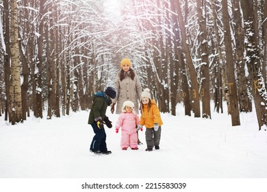 Happy Family Playing And Laughing In Winter Outdoors In Snow. City Park Winter Day.