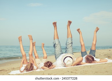 Fröhliche Familie, die tagsüber am Strand spielt. Konzept der freundlichen Familie.