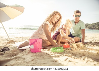 Happy Family Playing On The Beach And Build Some Sand Castle