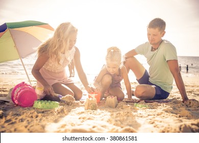 Happy Family Playing On The Beach And Build Some Sand Castle