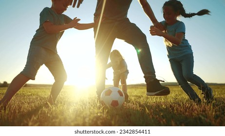 happy family playing soccer in the park. group of children in nature playing ball with father silhouette park. happy family kid dream concept. funny kids playing ball on grass sunlight in summer - Powered by Shutterstock