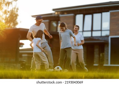 Happy Family Playing Soccer. Young Active People Enjoying Sunny Summer Evening Outdoor. Healthy Sport For Kids. Football Game Club.