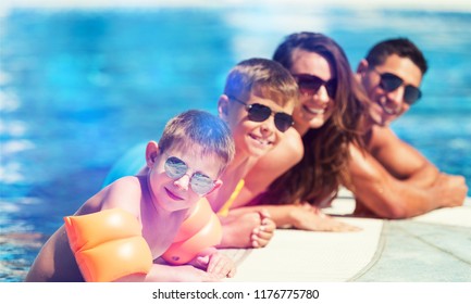 Happy Family Playing In Swimming Pool