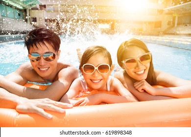 Happy Family Playing In Swimming Pool