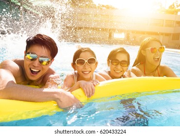 Happy Family Playing In Swimming Pool