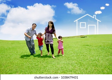 Happy Family Playing Together While Running In The Meadow With House Symbol Background