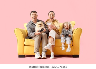 Happy family playing video game on sofa against pink background - Powered by Shutterstock