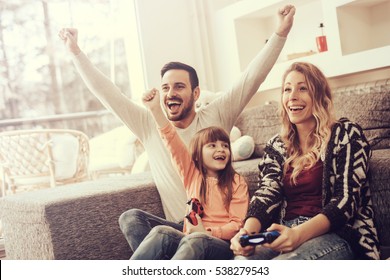 Happy Family Playing Video Games At Home And Having Fun Together.