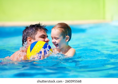 Happy Family Playing In Water Polo In The Pool