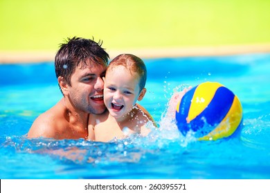 Happy Family Playing In Water Polo In The Pool