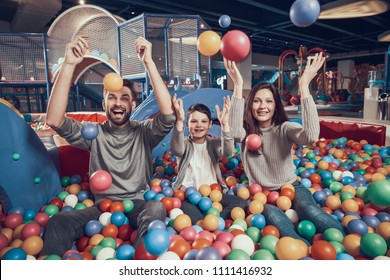 Happy Family In Pool With Balls. Family Rest, Leisure Concept. Spending Holiday Together. Entertainment Center, Mall, Amusement Park.