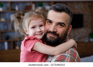 Happy Family Portrait. Cute Girl Hugging Her Beloved Dad Around Neck. Young Handsome Father Holding Nice Daughter In His Arms And Smiling. Family Love And Family Bond Concept.Happy Carefree Childhood