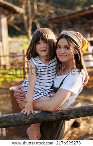Happy family portrait. Little girl with mother in domestic garden on warm sunny day. Spending time together on weekend at the countryside. Weekend with mom