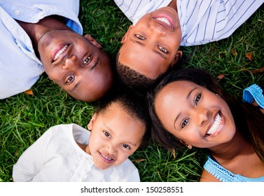Happy family portrait lying on the floor outdoors 
