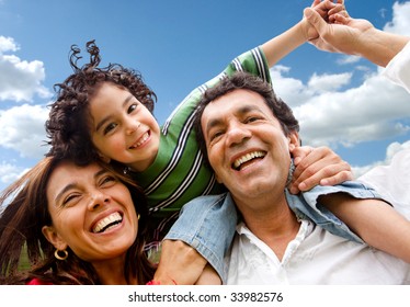 Happy Family Portrait Outdoors Smiling With A Blue Sky