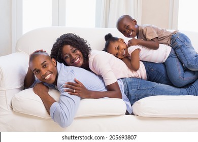 Happy family posing on the couch together at home in the living room