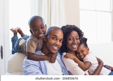 Happy family posing on the couch together at home in the living room - Powered by Shutterstock