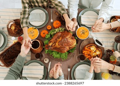 Happy family praying before dinner at festive table on Thanksgiving Day, top view - Powered by Shutterstock