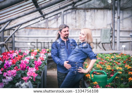 Happy family. Pregnant woman with her husband at greenhouse.