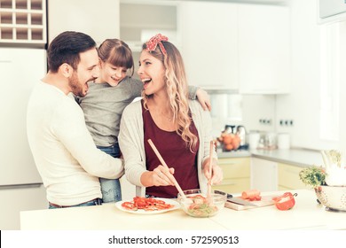 Happy family preparing meal from fresh vegetables.