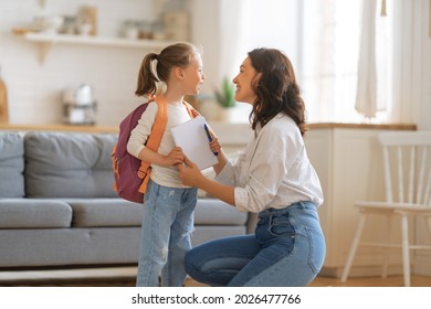 Fröhliche Familie bereitet sich auf die Schule vor. Kleines Mädchen mit Mutter.