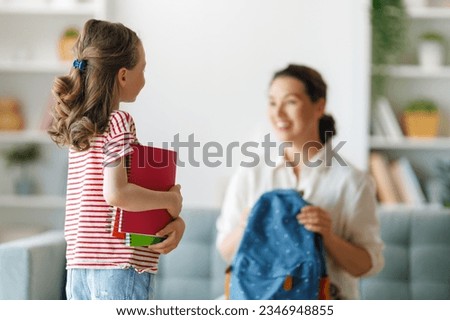 Happy family preparing for school. Little girl with mother.