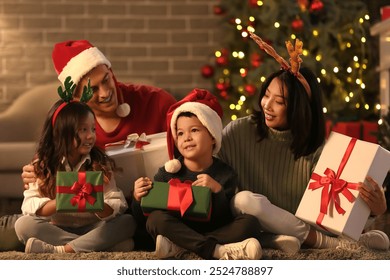 Happy family with presents at home on Christmas eve - Powered by Shutterstock