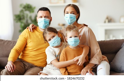 Happy Family In Protective Medical Masks In The Midst Of The Coronavirus Pandemic At Home